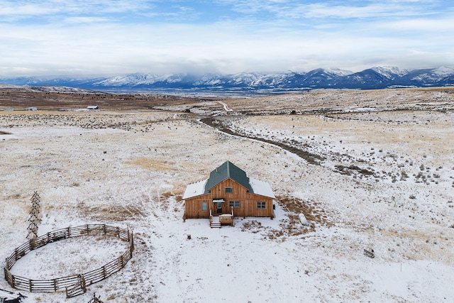 snowy aerial view with a mountain view and a rural view