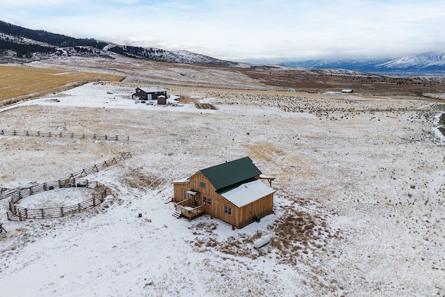 snowy aerial view featuring a mountain view and a rural view