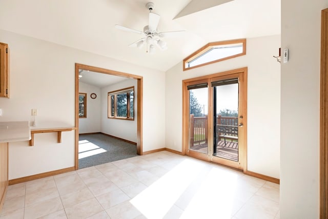 empty room featuring vaulted ceiling, ceiling fan, and light tile patterned flooring