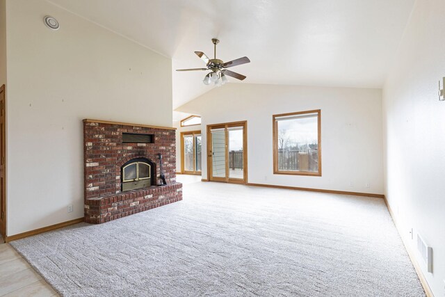 unfurnished living room featuring a brick fireplace, ceiling fan, plenty of natural light, and light tile patterned floors