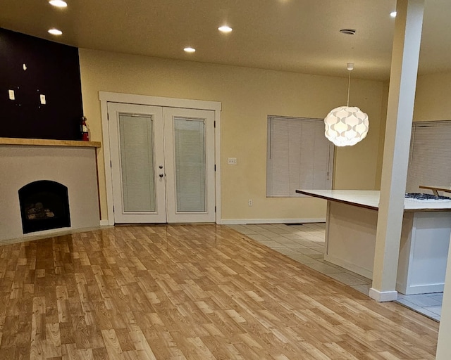 unfurnished living room with light hardwood / wood-style floors and french doors