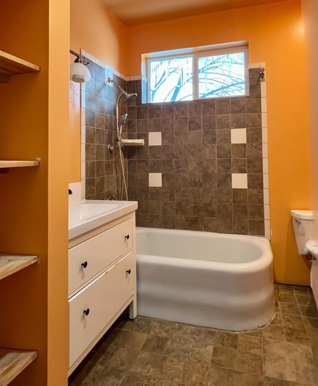 full bathroom with tiled shower / bath combo, toilet, and vanity