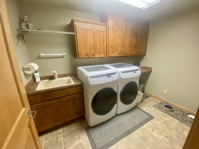 laundry room featuring washer and clothes dryer, a sink, light tile patterned floors, and cabinet space