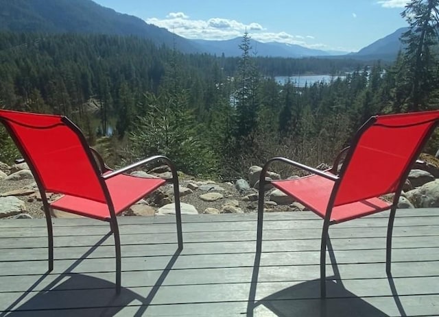 wooden terrace featuring a mountain view and a view of trees