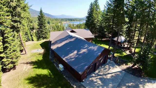 drone / aerial view with a forest view and a water and mountain view