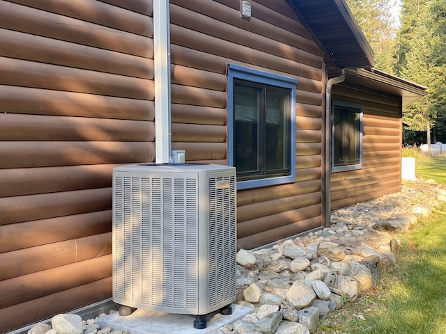 exterior details featuring cooling unit and log veneer siding