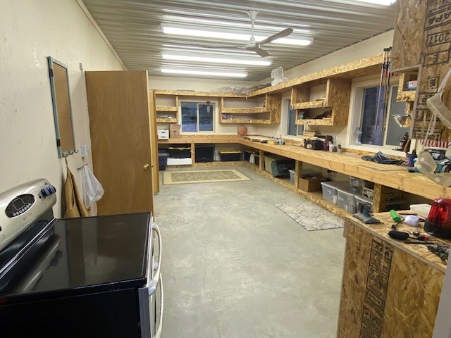 kitchen featuring concrete floors, stainless steel electric range oven, and ceiling fan