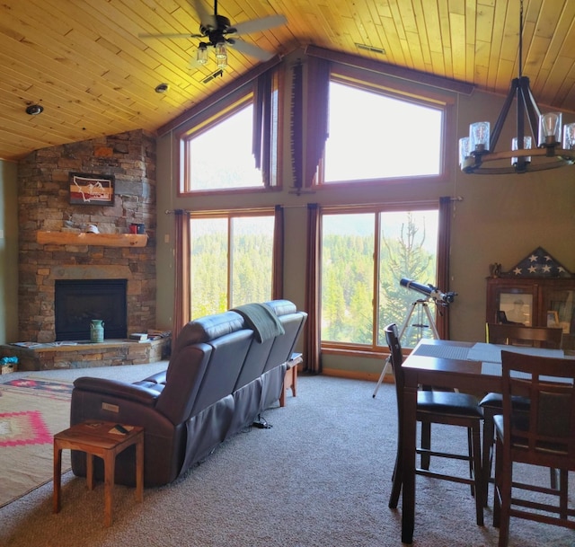 carpeted living area with vaulted ceiling, visible vents, a ceiling fan, wood ceiling, and a stone fireplace
