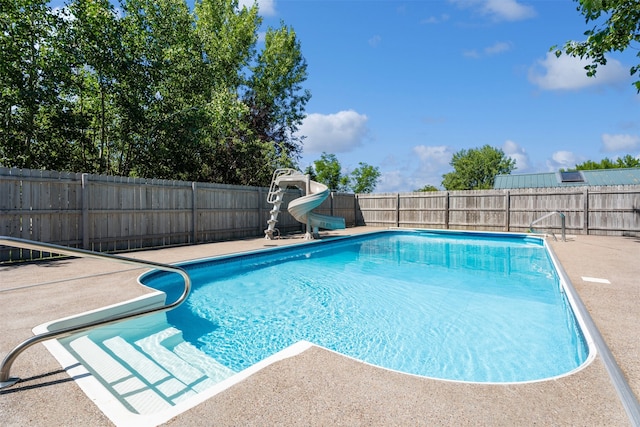 view of swimming pool featuring a water slide and a patio area