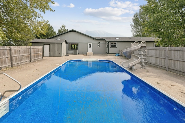 view of swimming pool with a water slide and a patio