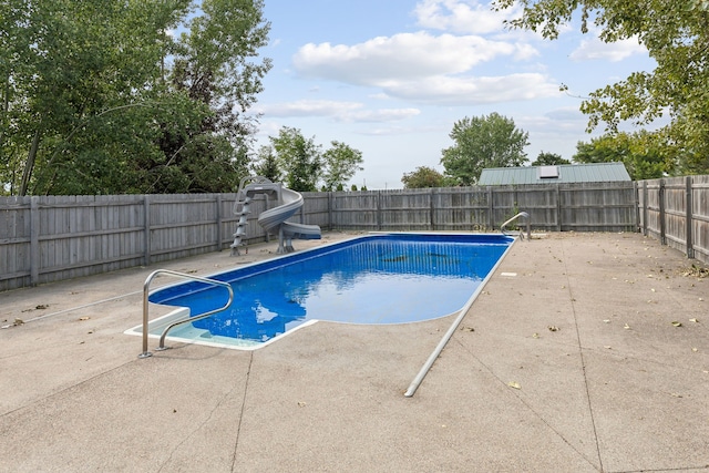 view of pool with a water slide and a patio area