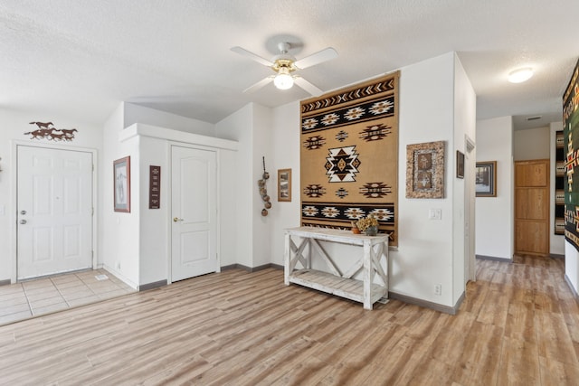 interior space featuring a textured ceiling, ceiling fan, and light hardwood / wood-style floors