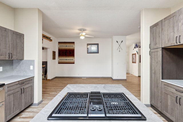 kitchen with ceiling fan, backsplash, light hardwood / wood-style floors, and a textured ceiling