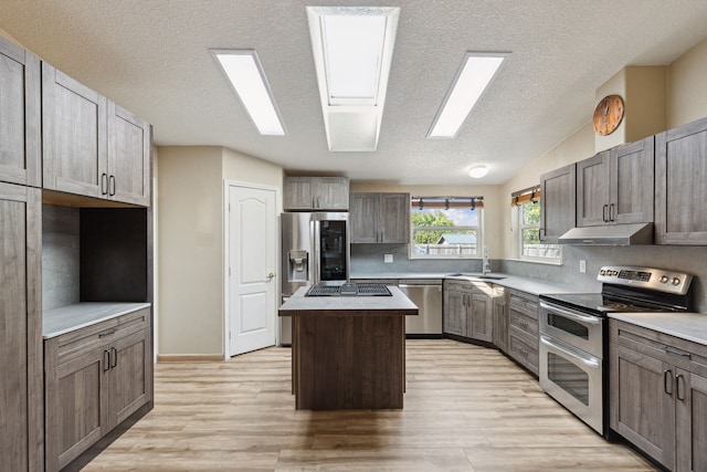 kitchen featuring light hardwood / wood-style flooring, a kitchen island, stainless steel appliances, and sink