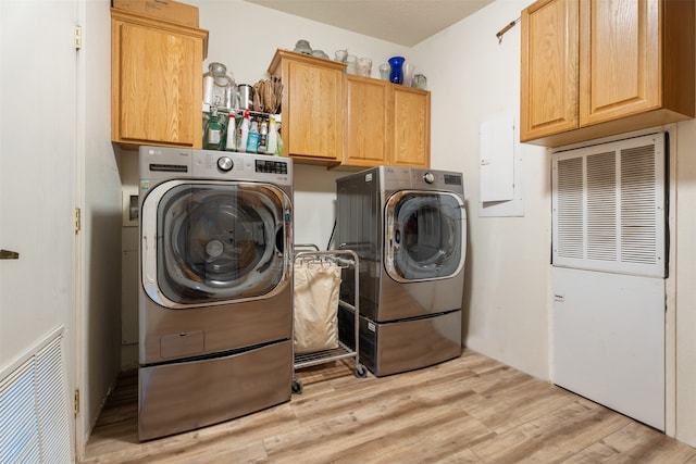 washroom featuring electric panel, separate washer and dryer, cabinets, and light hardwood / wood-style flooring