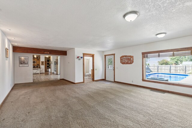 unfurnished room with a textured ceiling and light colored carpet