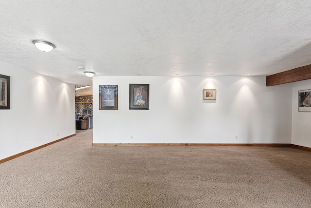 basement with a textured ceiling, a large fireplace, and carpet flooring