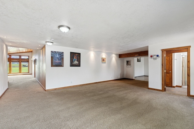 carpeted empty room featuring a textured ceiling