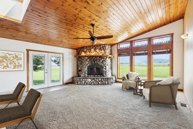 living room featuring a fireplace, light colored carpet, a healthy amount of sunlight, and ceiling fan