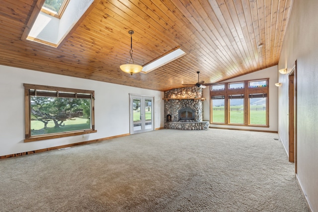 unfurnished living room featuring a fireplace, a wealth of natural light, ceiling fan, and carpet floors