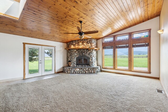 unfurnished living room with a healthy amount of sunlight, ceiling fan, lofted ceiling with skylight, and a fireplace