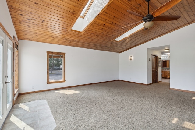 interior space with ceiling fan, vaulted ceiling with skylight, plenty of natural light, and wooden ceiling