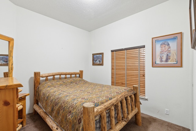 bedroom with dark colored carpet and a textured ceiling