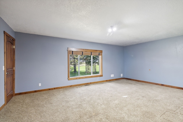 carpeted empty room featuring a textured ceiling