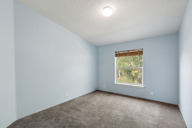 carpeted empty room with a textured ceiling