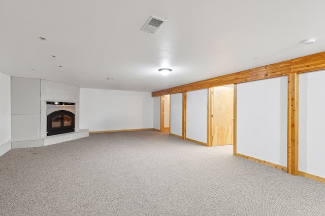 basement featuring carpet and a fireplace