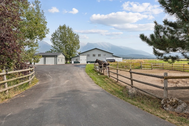 view of front of home featuring a garage, a rural view, a mountain view, and an outdoor structure