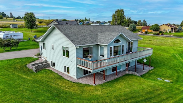 back of house featuring a balcony and a lawn