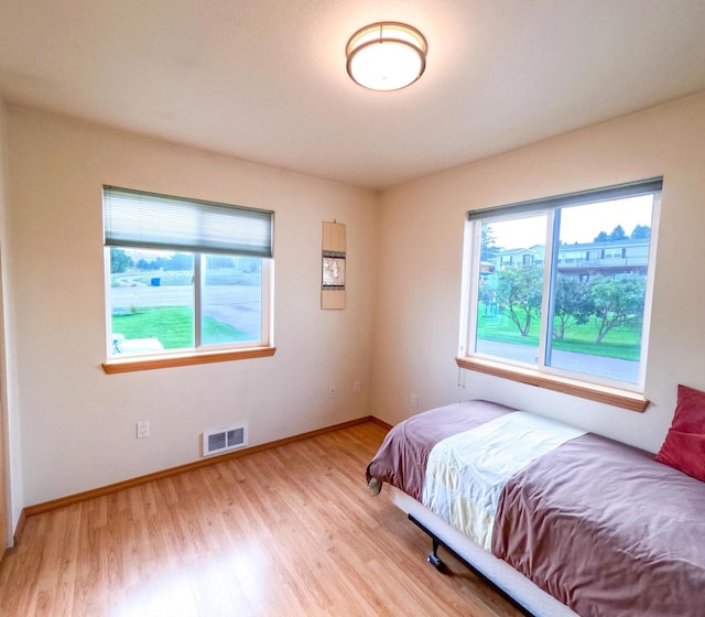 bedroom featuring multiple windows and light hardwood / wood-style floors