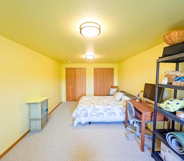 carpeted bedroom with two closets and a textured ceiling