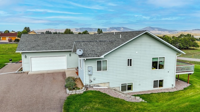 exterior space with a mountain view, a garage, and a front yard