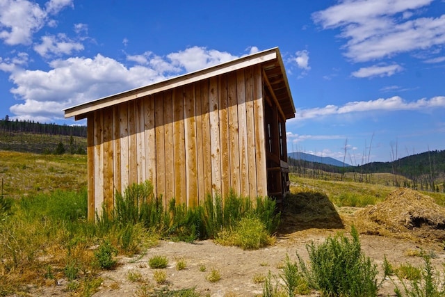 view of outdoor structure with a rural view and a mountain view