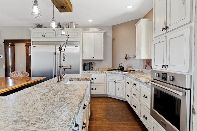 kitchen with pendant lighting, recessed lighting, appliances with stainless steel finishes, dark wood-style floors, and white cabinetry