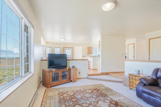 living room featuring carpet flooring, a baseboard heating unit, and baseboards