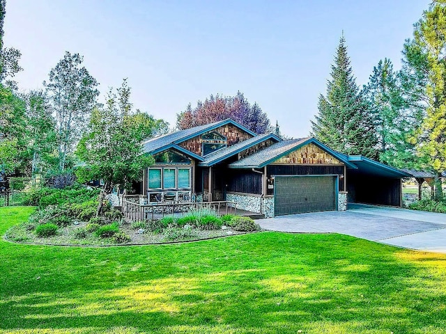 view of front of home with a front lawn, covered porch, and a garage