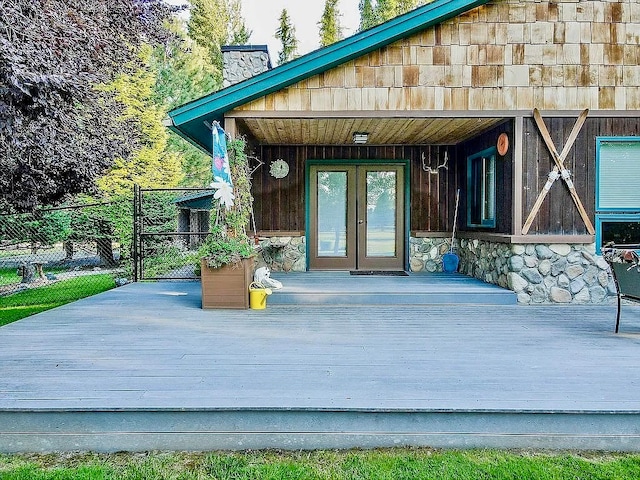 view of exterior entry with french doors and a wooden deck