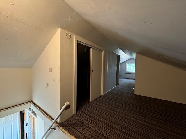 bonus room featuring dark carpet and vaulted ceiling