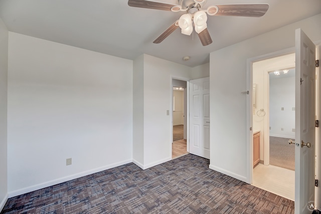 unfurnished bedroom featuring dark colored carpet and ceiling fan