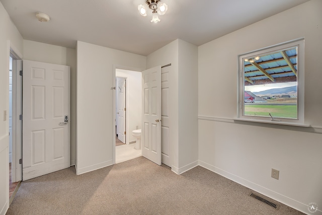 unfurnished bedroom with carpet and ensuite bath