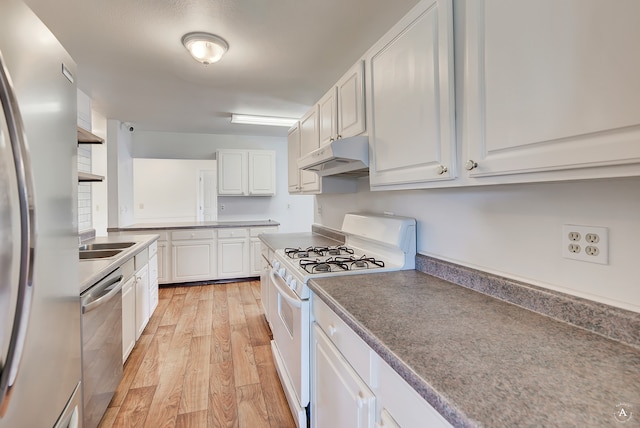 kitchen with light hardwood / wood-style flooring, sink, appliances with stainless steel finishes, and white cabinets