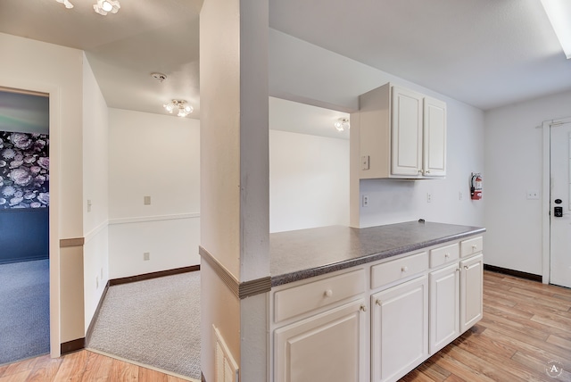 kitchen with light wood-type flooring and white cabinets