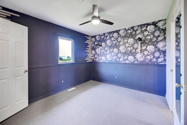 carpeted spare room featuring ceiling fan