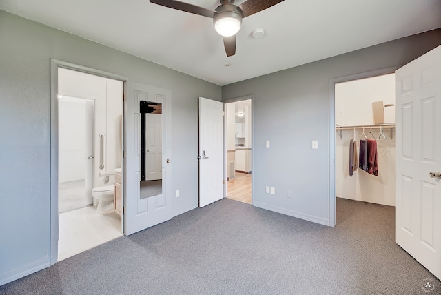 unfurnished bedroom featuring connected bathroom, ceiling fan, a closet, carpet flooring, and a walk in closet