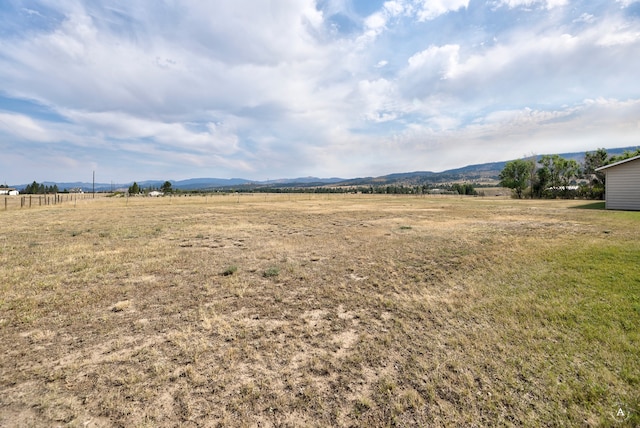 view of yard with a rural view and a mountain view