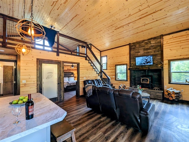 living room with dark wood-type flooring, wood ceiling, wooden walls, and a healthy amount of sunlight