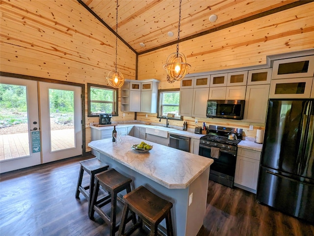 kitchen featuring a center island, stainless steel appliances, dark hardwood / wood-style flooring, high vaulted ceiling, and pendant lighting